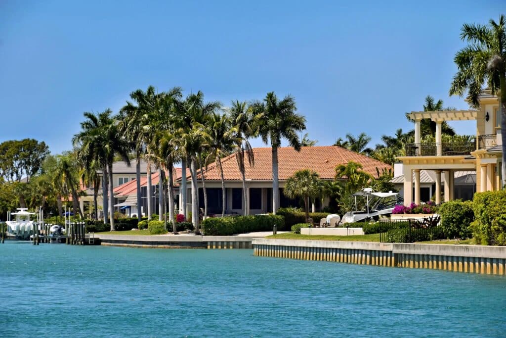 pexels-photo-37485070-37485070 Scenic view of luxury waterfront villas and palm trees under a clear blue sky.