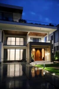 Stunning modern luxury house exterior lit up at night with clean architectural design.